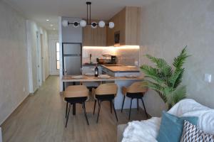 eine Küche mit einer Theke und Hockern in einem Zimmer in der Unterkunft Vista Mar Torrevieja in Torrevieja + 30 Fotos