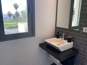 a bathroom with a white sink and a mirror at Refugio del Atlántico in El Puerto de Santa María +4 photos