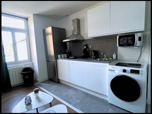 een keuken met een wasmachine en een wastafel bij SQ Appart-ment in Saint-Quentin
