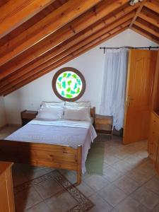 a bedroom with a large bed and a window at Mantemi house in Skopelos Town