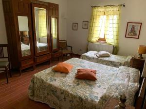 a bedroom with two beds and a mirror at Podere Piccini with pool in Val d'Orcia-Tuscany in Piancastagnaio