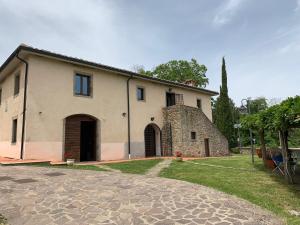 a large white building with a large door at Podere Piccini with pool in Val d'Orcia-Tuscany in Piancastagnaio