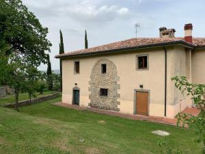 a large white house with a grass yard at Podere Piccini with pool in Val d'Orcia-Tuscany in Piancastagnaio