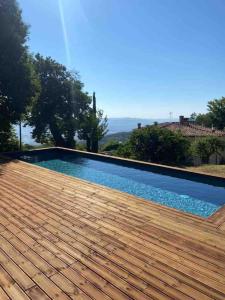 a swimming pool with a wooden deck next to a house at Podere Piccini with pool in Val d'Orcia-Tuscany in Piancastagnaio