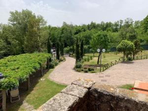 a view of a garden with a stone wall at Podere Piccini with pool in Val d'Orcia-Tuscany in Piancastagnaio