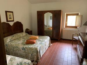 a hotel room with two beds and a mirror at Podere Piccini with pool in Val d'Orcia-Tuscany in Piancastagnaio