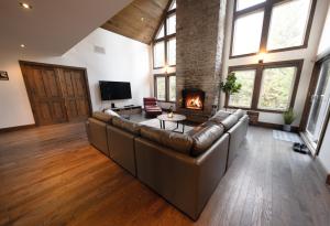 a large living room with a couch and a fireplace at Luxury with hot tub 300mbps Wifi Games & more ! in Saint Adolphe D'Howard +23 photos