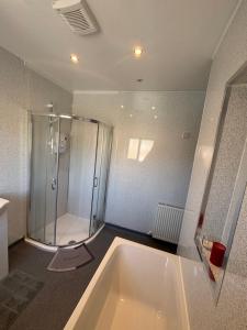 a bathroom with a shower and a large tub at Kane's Place in Birkenhead +67 photos