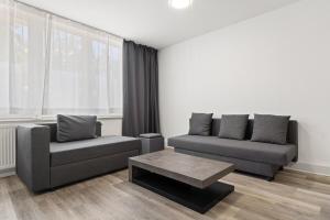 ein Wohnzimmer mit zwei Sofas und einem Couchtisch in der Unterkunft Cozy Cologne Premium Apartment with free parking! NEW! in Köln
