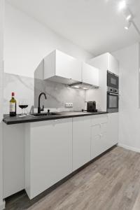 a white kitchen with white cabinets and a sink at Cozy Cologne Premium Apartment with free parking! NEW! in Cologne