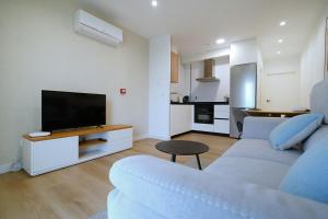 a living room with a couch and a flat screen tv at GALIHOST - Apartamentos Vento Mareiro in Sanxenxo