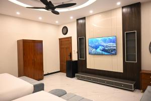 a living room with a tv on a wall at Ariston Suites in Islamabad