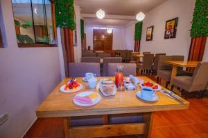 a wooden table with plates of food on top of it at Munay Ñusta Cusco in Cusco