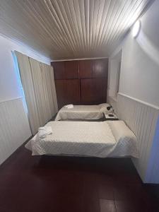 two beds in a small room with a ceiling at La Casita de Salta 421 in Concordia