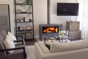 a living room with a couch and a fireplace at Antler & Oak Cottage: Provincial Luxe In Moss Vale in Moss Vale