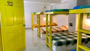 a room with three bunk beds and a yellow door at CasaColibri in Pasto