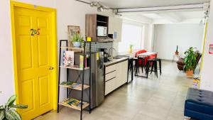 a kitchen with a yellow door and a living room at CasaColibri in Pasto