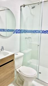 a bathroom with a toilet and a glass shower at CasaColibri in Pasto +10 photos