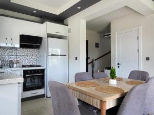 Una cocina y un comedor con mesa y sillas. en Villa Verde, en Dalaman