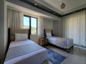 Un dormitorio con dos camas y una ventana. en Villa Verde, en Dalaman