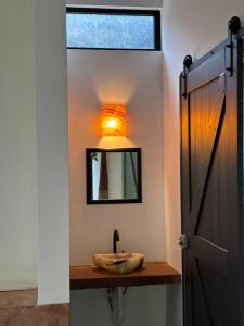 a bathroom with a sink and a mirror on a wall at Casa La Kin in Cacahuatán +11 photos