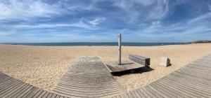 a bench on a sandy beach with a pole at GuestReady - Bright & Inviting Stay in Vila Nova de Gaia +45 photos