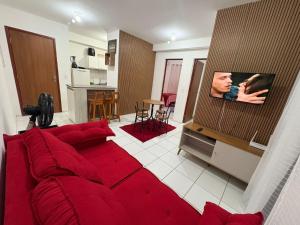 a living room with a red couch and a tv at APT Bela Cintra PRIME 3 km da praia do Aracagy in São Luís +28 photos