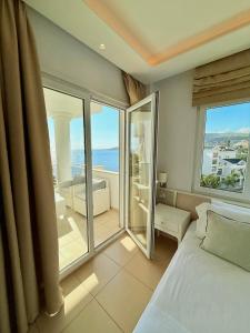 a bedroom with a bed and a view of the ocean at Limani Deluxe Apartments in Sarandë +82 photos