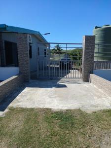 a gate to a house with the ocean in the background at Gounders Apartmemt in Sigatoka