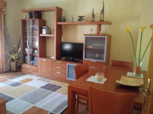 a living room with a wooden table and a television at Casa SUROESTE - Zona El Colorado, Conil de la Frontera in Roche