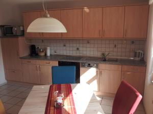 a kitchen with wooden cabinets and a table and a sink at FeWo Thul in Plein