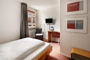 a bedroom with a bed and a desk with a computer at Hotel an der Marienkirche in Lübeck