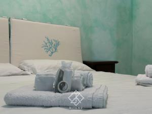 a bed with towels and a camera on top of it at Domus Aurora in Villasimius