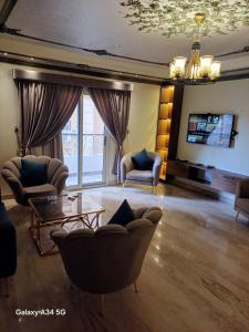 a living room with couches chairs and a tv at الفيروز شقه فندقيه الفيوم دله in Fayoum Center +17 photos