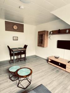 a living room with a table and a tv at Apartment 4 - Haus Heinke am Deich in Friedrichskoog-Spitz