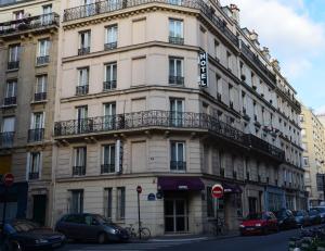 un bâtiment dans une rue avec des voitures garées devant elle dans l'établissement Hotel du Chemin Vert, à Paris