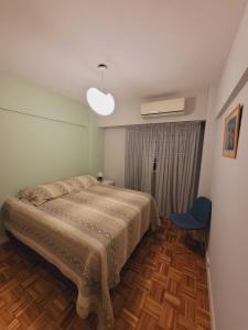 a bedroom with a bed and a blue chair at Hermoso dpto en el corazón de Belgrano in Buenos Aires