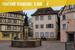 a fountain in the middle of a town with buildings at Bretzel Twin Petite Venise Vieille Ville City Center Wi-Fi in Colmar