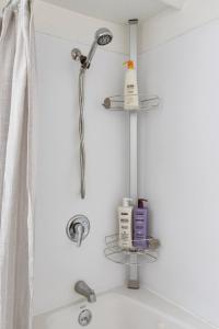 a shower with two shelves above a bath tub at Stylish Daylight Basement Apartment- Patio + Grill in Seattle