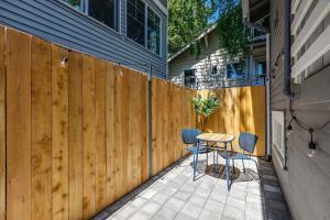 a patio with a wooden fence and a table and chairs at Stylish Daylight Basement Apartment- Patio + Grill in Seattle