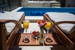 un tavolo con due bicchieri e un vaso di fiori di Apartments La Bohème a Dubrovnik