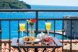 un tavolo con un piatto di cibo e bevande su un balcone di Apartments La Bohème a Dubrovnik