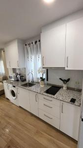 a kitchen with white cabinets and a sink at Encarnita Apartamento - Monachil in Monachil +19 photos