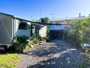 a house with a driveway next to a garage at Bed And Breakfast at Tirohanga Beach in Tirohanga