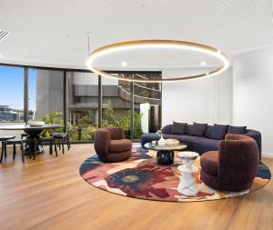 布里斯班Queen's Wharf Residences的客厅里有一张蓝色的沙发和椅子