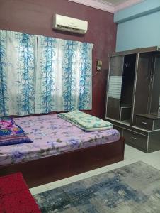 a bedroom with a bed and a dresser and a window at Ekaira homestay in Tambun