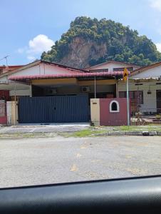 a building with a mountain in the background at Ekaira homestay in Tambun
