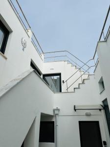 vista su un edificio bianco con scale di PENICHE As Estrelas Proches centre ville et petite plage Trois établissements indépendants climatisés et de tout confort a Peniche