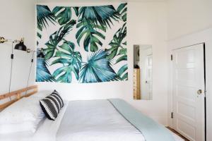 una camera da letto con un letto con una stampa tropicale sul muro di Radiant, Low-Key Apartment with powerful A/C a Seattle