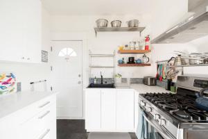 una cucina con mobili bianchi e un forno a piano cottura di Radiant, Low-Key Apartment with powerful A/C a Seattle